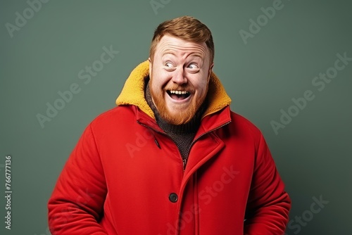 Portrait of a funny red-haired man in a red jacket and a yellow scarf