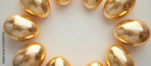 Golden Easter eggs arranged in a circle on a white background, representing Easter themes in a still life pastel-toned image.