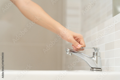 Save water. woman keeps turning off the running water in the bathroom to protect environment. Greening planet, reduce global warming, Save world, life, future, risk energy, crisis , water day. photo