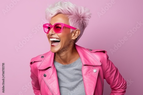 Portrait of a smiling punk girl in pink sunglasses and leather jacket © Inigo