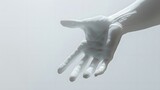 gesture of serenity: a symbolic white hand outstretched against a pure white wall