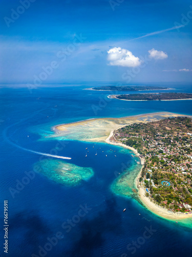 Aerial view of a tiny tropical island surrounded by large, fringing coral reef and blue, warm ocean (Gili Air, Indonesia) © whitcomberd