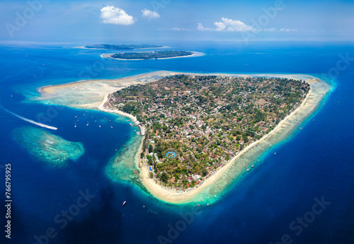Fototapeta Naklejka Na Ścianę i Meble -  Aerial view of a tiny tropical island surrounded by large, fringing coral reef and blue, warm ocean (Gili Air, Indonesia)
