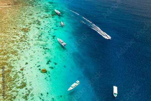 Top down aerial view of snorkel boats and tourists over a tropical coral reef in a warm ocean © whitcomberd