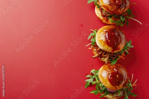Three Hamburgers With Ketchup on a Red Surface © Yasir