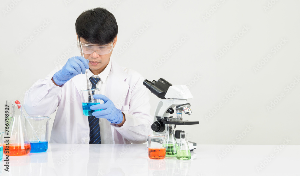 Portrait asian man student scientist doctor gown one person sti in lab looking hand holding test tube chemist. caused by mixing reagents in scientific research laboratories and microscope on table Portrait asian man student scientist doctor gown one person sti in lab looking hand holding test tube chemist. caused by mixing reagents in scientific research laboratories and microscope on table