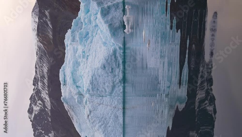 Vertical Video, Iceberg in Glacial Water Under Hills and Glacier photo