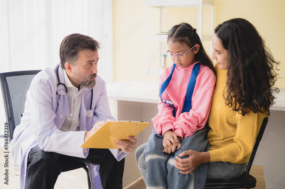 Doctor man care caucasian sitting use stethoscope check girl sick illness daughter who came to hospital with mother woman three people with talk helping support give advice inside treatment room Doctor man care caucasian sitting use stethoscope check girl sick illness daughter who came to hospital with mother woman three people with talk helping support give advice inside treatment room