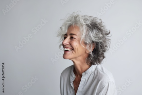 Portrait of a happy senior woman with grey hair and white shirt smiling