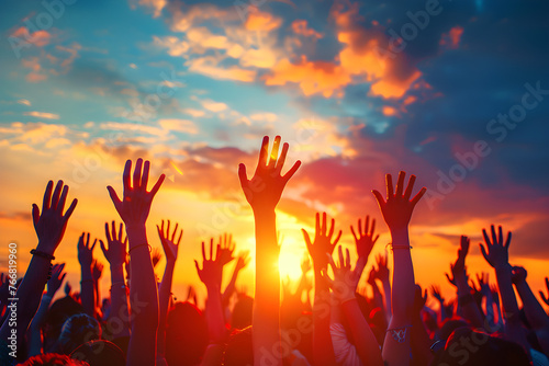 Christian people raising hands in worship and praise against a sunset background.