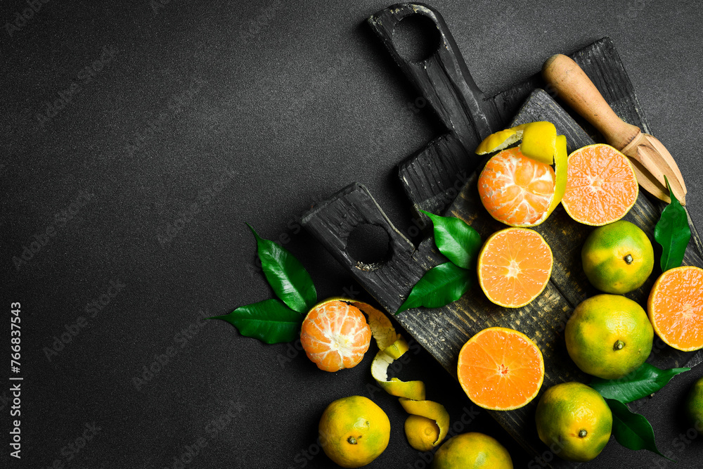 Fresh ripe Tangerine orange. Top view, on a dark stone background. Autumn fruits. - obrazy, fototapety, plakaty 