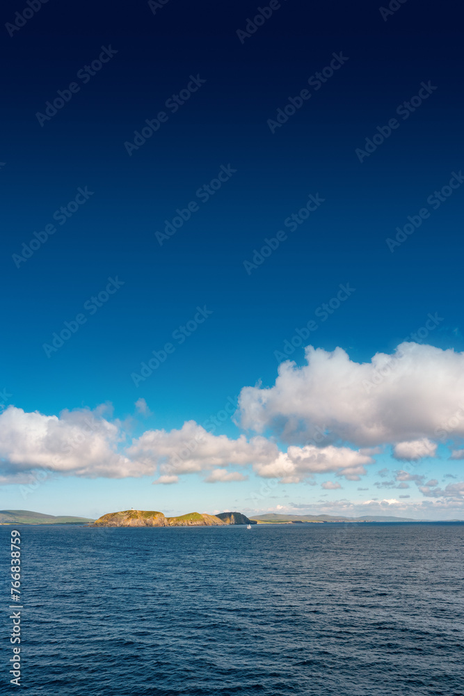 Cover page with oceanic seashore, at North Sea, summer sunny day with a big island, blue sky and copy space with gradient background
