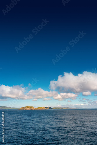 Cover page with oceanic seashore, at North Sea, summer sunny day with a big island, blue sky and copy space with gradient background