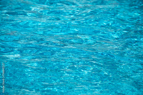 Ripple Water in swimming pool with sun reflection. Wavy water background.