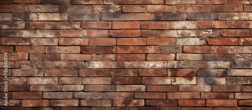 A detailed closeup of a brown brick wall showcasing the intricate pattern of rectangular bricks, a classic building material made of composite materials like wood and stone