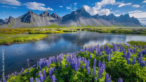 A stunning landscape of Iceland's Stokksnes, featuring the majestic flat-topped mountain and vibrant blue skies. The scene includes an enchanting lake reflecting distant mountains