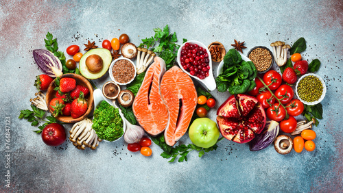 Top view. Healthy food selection on gray background. Detox and clean diet concept. Foods high in vitamins, minerals and antioxidants. Anti-aging foods.