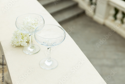 Two glass glasses with flowers on the background of the sea. photo