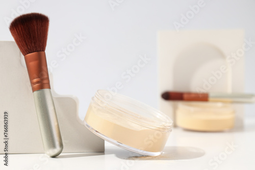 Face powder with a brush, on a light background.
