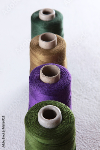 Bobbins with multicolored yarn. Multicolored threads. Yarn. Sewing threads. Type of thread. The texture of multicolored threads in skeins.