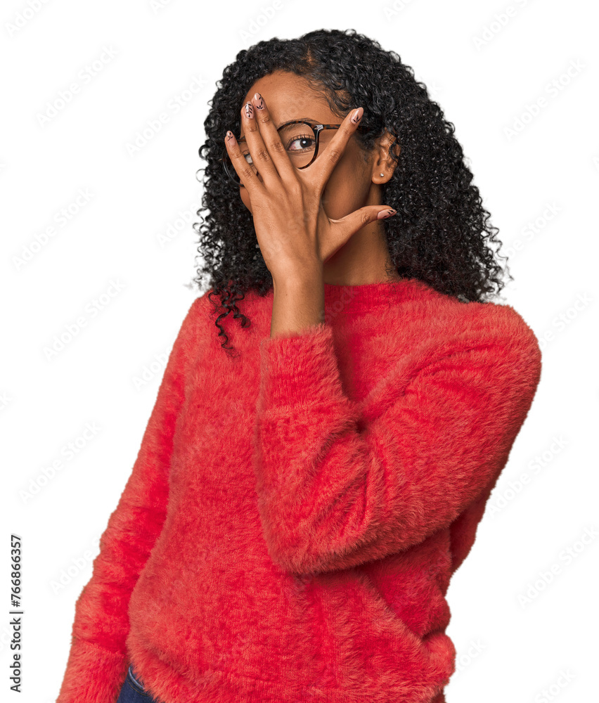 African American woman in studio setting blink at the camera through fingers, embarrassed covering face. African American woman in studio setting blink at the camera through fingers, embarrassed covering face.