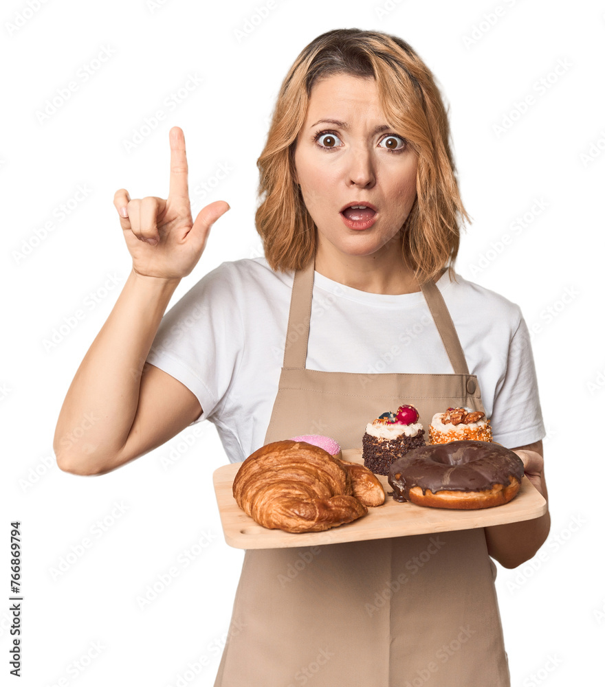 Middle-aged Caucasian woman baker with pastries having an idea, inspiration concept. Middle-aged Caucasian woman baker with pastries having an idea, inspiration concept.