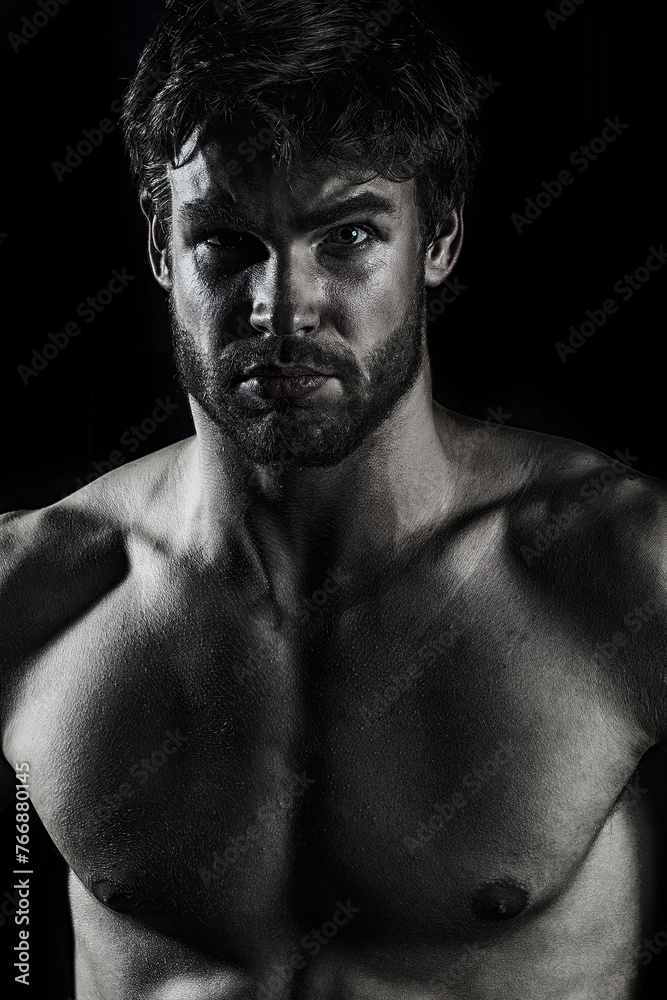 Fototapeta premium Sexy naked muscular man. Sexy handsome playboy on black. Handsome muscular man relaxing. Portrait of a sexy man with naked muscular body. Strong athletic man. Fit male model.