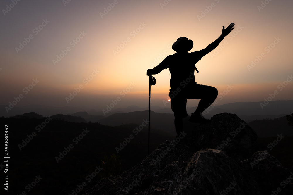 Climber success, silhouette achievements successful arm up man is on top of hill celebrating success with sunrise.