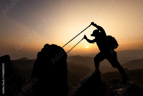Active climbers enjoy the scenery. Male and female backpackers with backpacks and crutches on top of a mountain.