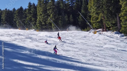 Winter season at Bansko ski resort in Bulgaria with a view to the skiers having fun on the slope photo