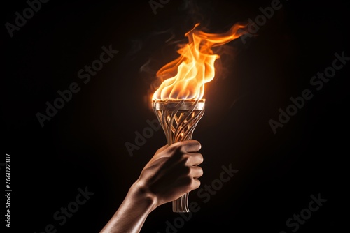 A hand holding a burning torch, the glow of the fire illuminating the surroundings © Maelgoa