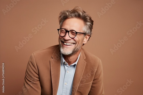 Cheerful mature man in eyeglasses smiling and looking at camera