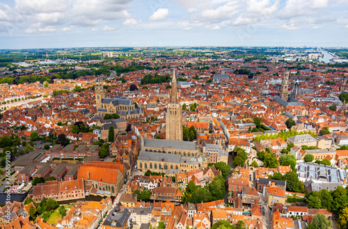 Bruges, Belgium. Church of Our Lady. City center. Residential areas. Panorama of the city. Summer day, cloudy weather. Aerial view