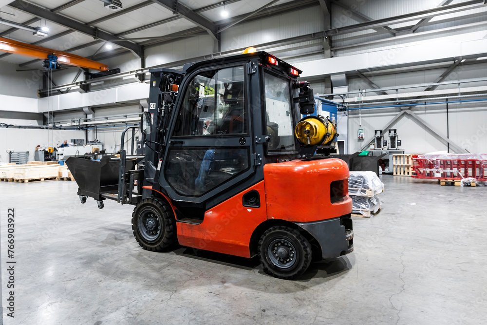 Red forklift in illuminated modern factory Red forklift in illuminated modern factory