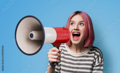 Funny very happy pink woman wear dent dental tooth braces brackets, sweater advertise using mega phone megaphone loudspeaker bullhorn, open mouth, isolated blue wall background. Sales ad concept
