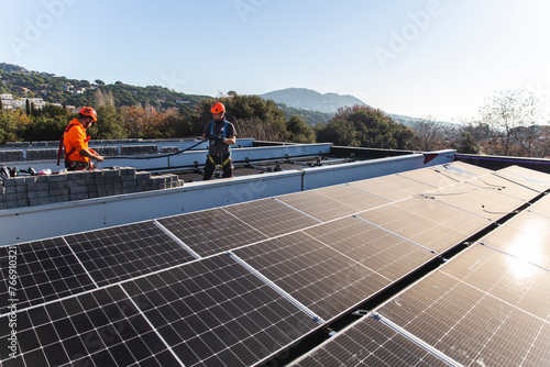 Engineers installing solar panels on rooftop photo