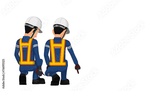 Two workers are considering something on the floor