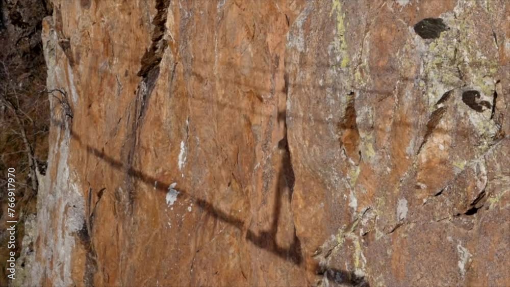 Man in body harnesses feature life-safety, attaches hooks to iron brackets, climbs rock, active lifestyle of people, mountaineering, viaferrata in mountains of pyrenees, High quality 4k footage