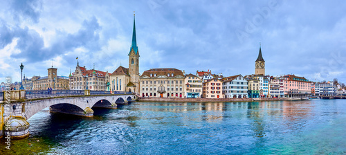 Panorama of the riverside housing of Limmat river with Peterskirche and Fraumunster churches, Zurich, Switzerland photo