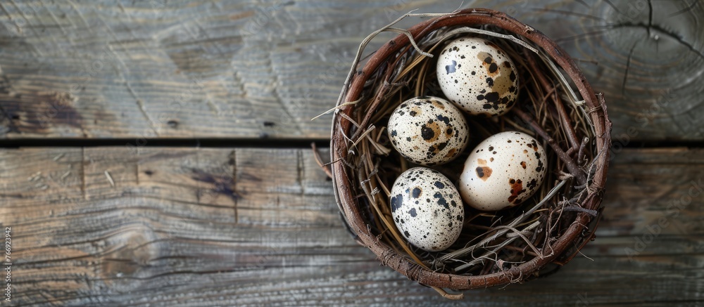 Three quail eggs arranged in a nest on a wooden rustic table, seen from above. Three quail eggs arranged in a nest on a wooden rustic table, seen from above.