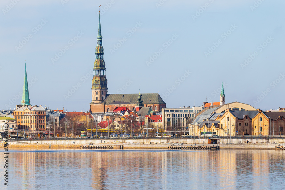 Fototapeta premium Riga towers and rooftops day time skyline. Sunny spring time shade on the buildings in Riga, next to a market and new project of railway in the Baltic States