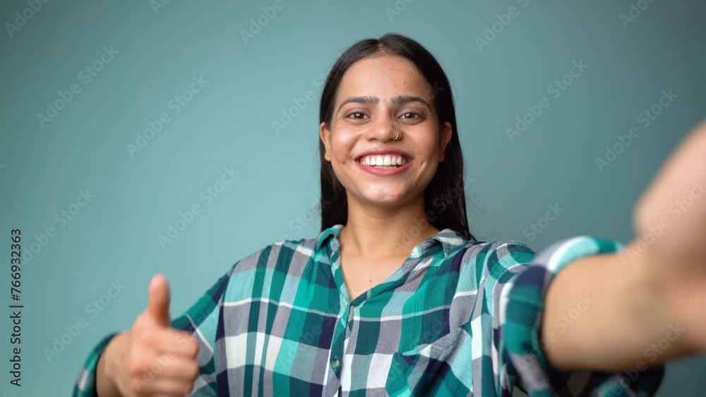 Young woman taking selfie portrait, POV shot of a beautiful Asian Indian girl taking her picture and showing thumbs up gesture Young woman taking selfie portrait, POV shot of a beautiful Asian Indian girl taking her picture and showing thumbs up gesture