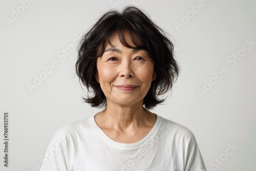A woman with short hair and a white shirt is smiling