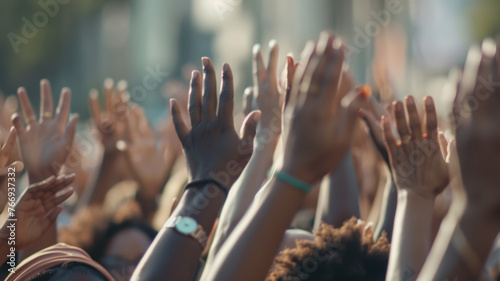 Energetic crowd raising hands in unison, expressing joy and unity.