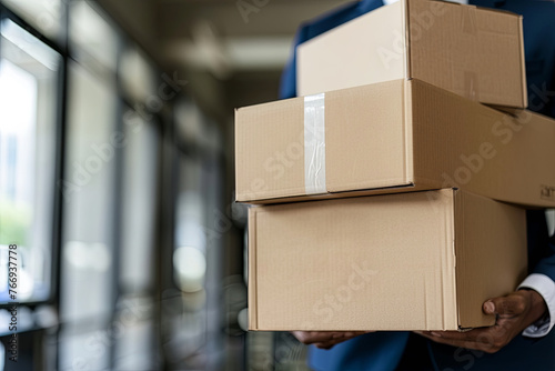 Businessman exerting effort to move a stack of cardboard boxes photo