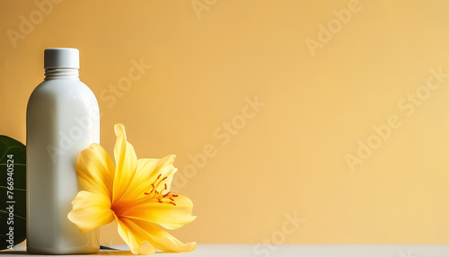 A bottle of lotion sits on a table next to a yellow flower