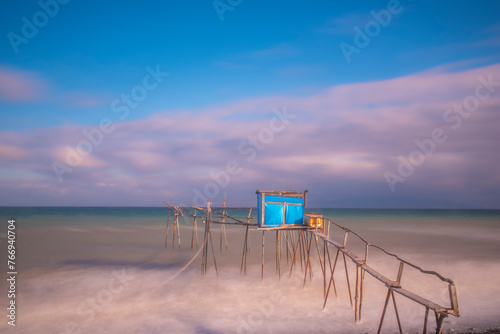 wooden fishing piers lying on the sea of Marmara cloudy weather sunset hours while the waves hit the beach