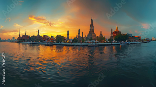 A panoramic view of Wat Arun temple at sunset in Bangkok, Thailand with the river and city in the background