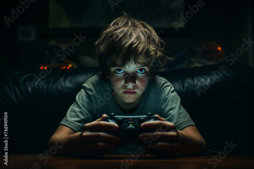 a boy of about 9 years old playing the video game console in his dark room for hours