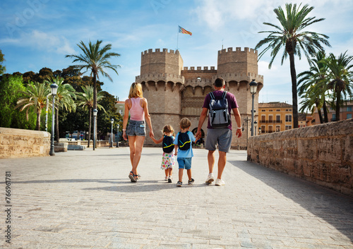 Photography Parents with kids walk in front of famous Torres de Serrans